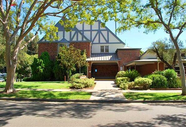 a school with green trees next to it
