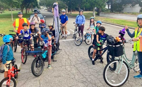 group of students and adults on bikes waiting by an intersection
