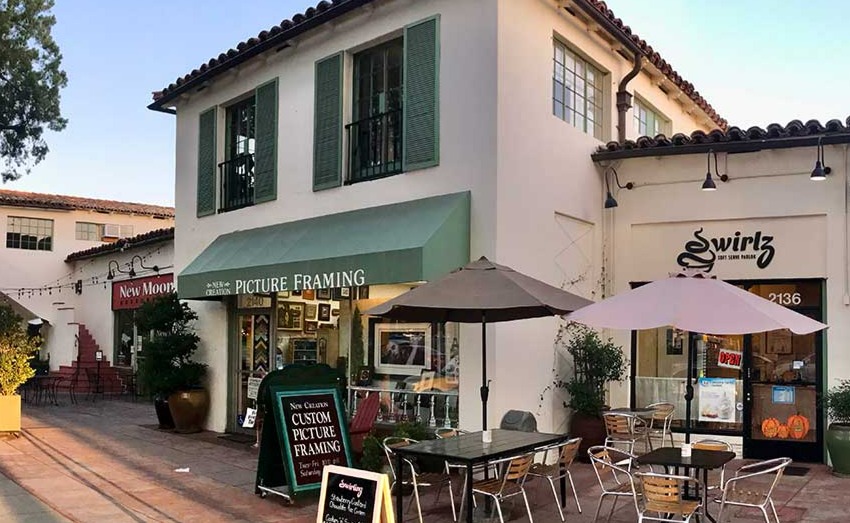 Three storefronts with tables and chairs in front