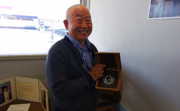 A smiling man holding a camera