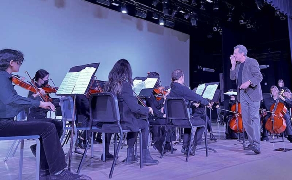 an orchestra made of students and a guest conductor