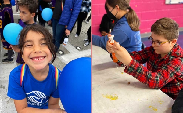 A girl smiles at camera and a boy is working with a device