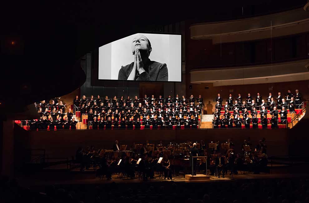 orchestra and chorale with a projection of a silent film behind them