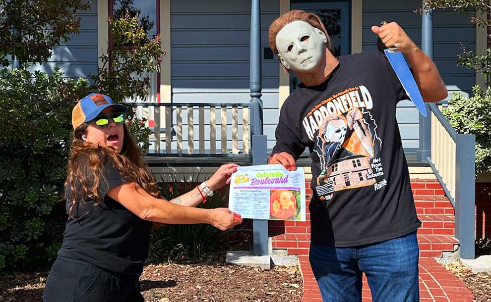 A woman in a cap and a man with a mask fight over a newspaper