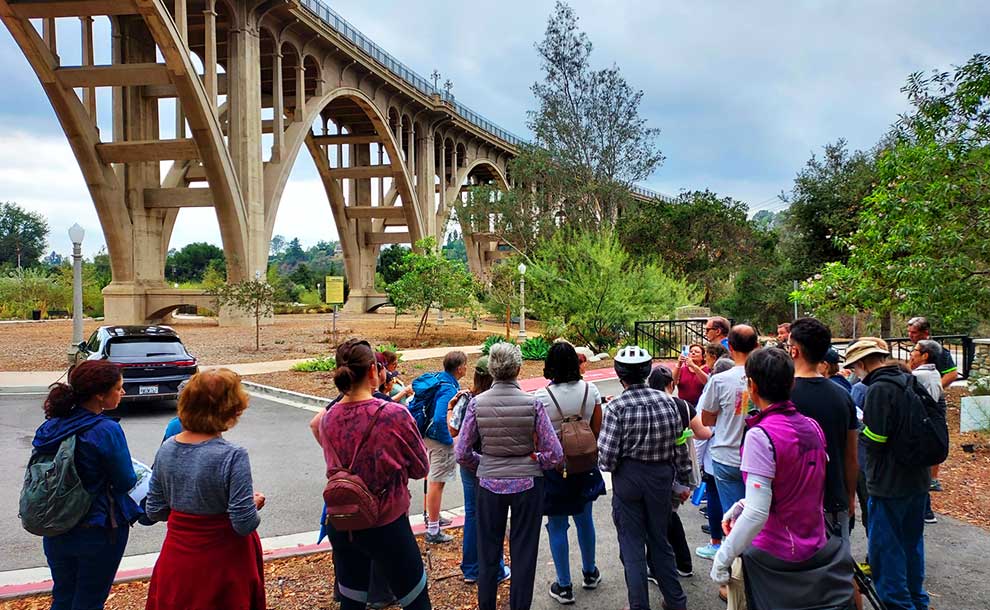 people gathering near a bridge