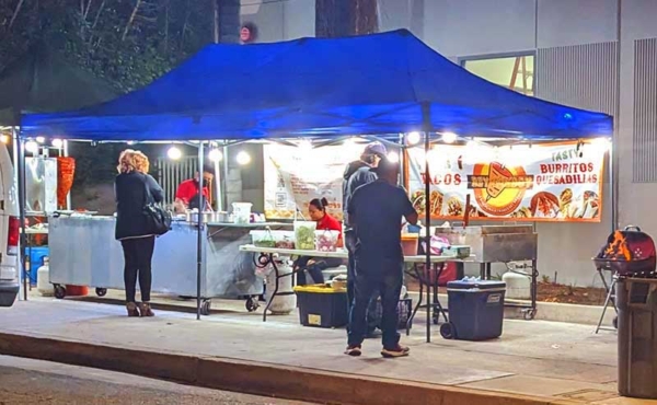Street vendors inside a food tent with lights