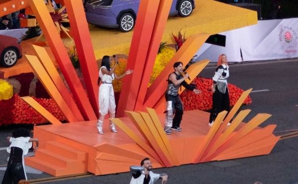 A singer and two dancers perform on stage