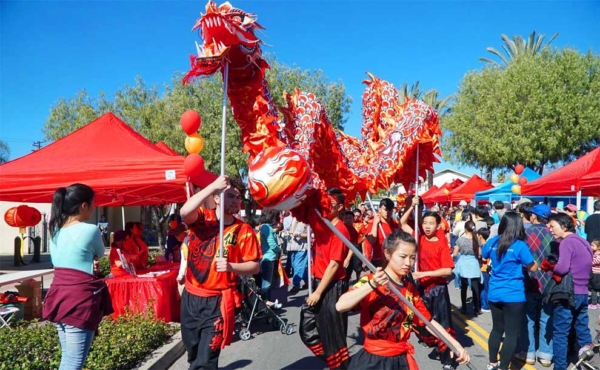 people dressed as a dragon doing a dance on the street