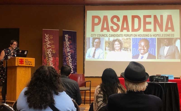 a woman speaking at a podium with photos of candidates in the background