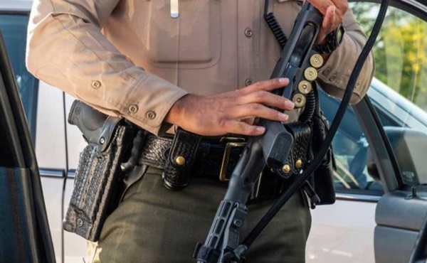 A sheriff holding a rifle and a gun