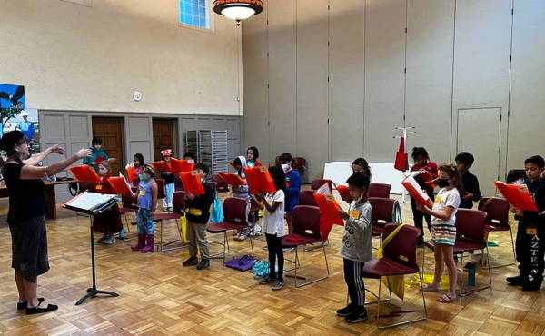 a teacher conducting a choir of children