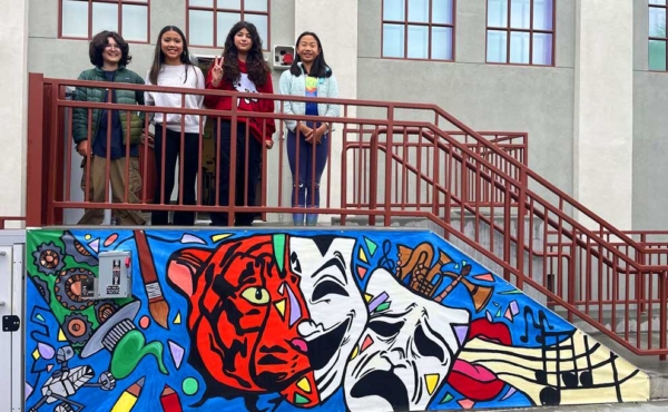 students standing and below them a mural