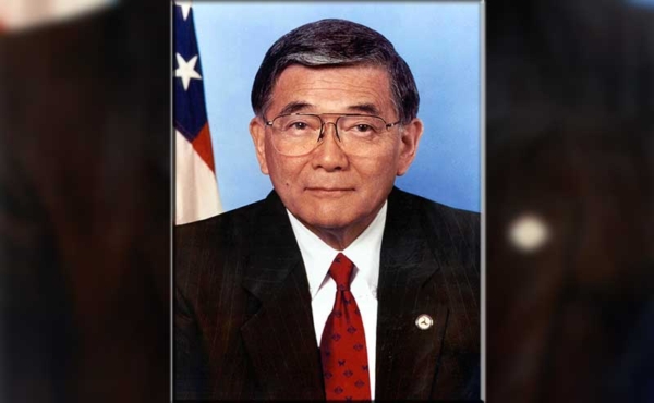 A man standing in front of a flag
