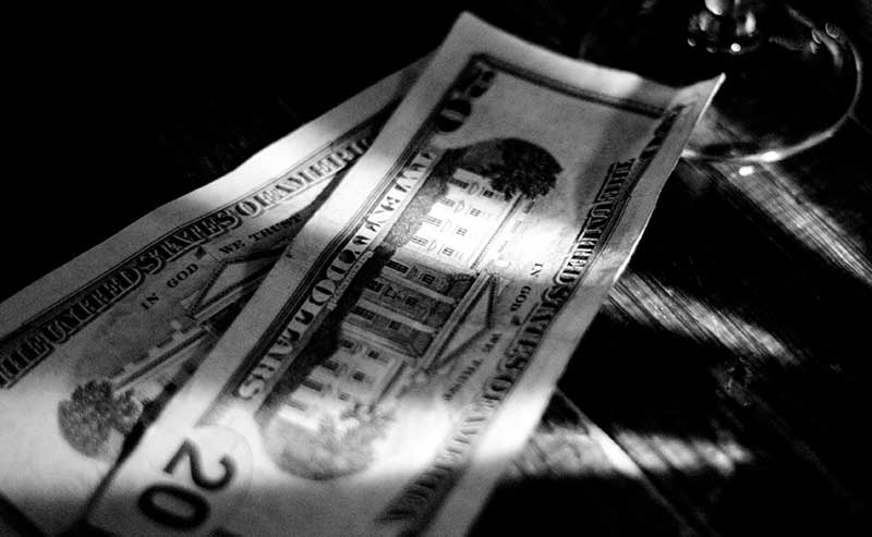 black and white photo of dollar bills in the shadows
