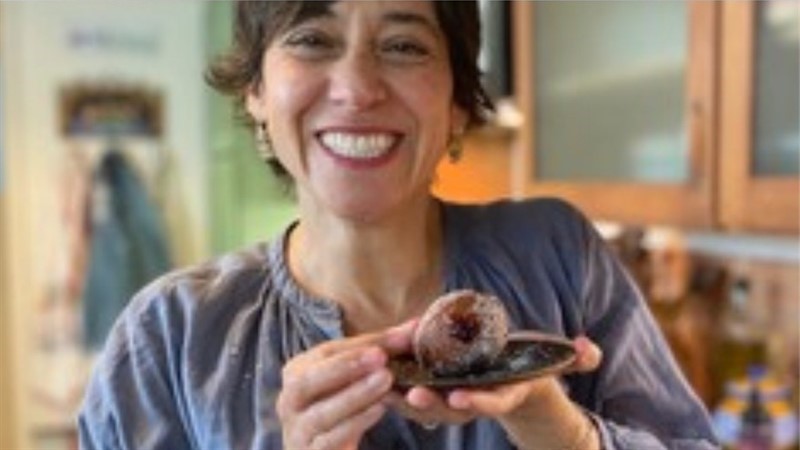 A woman holding food and smiling