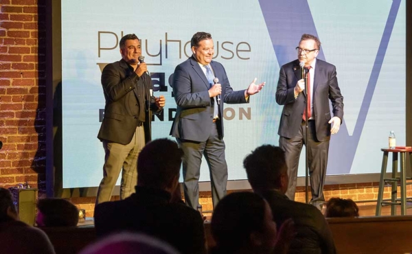 three people on stage with microphones