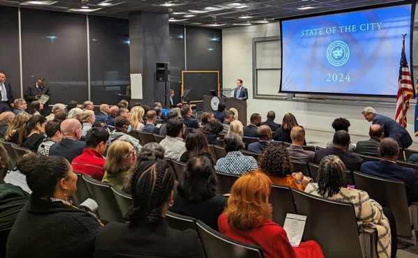 a person giving a speech on a podium to a full auditorium