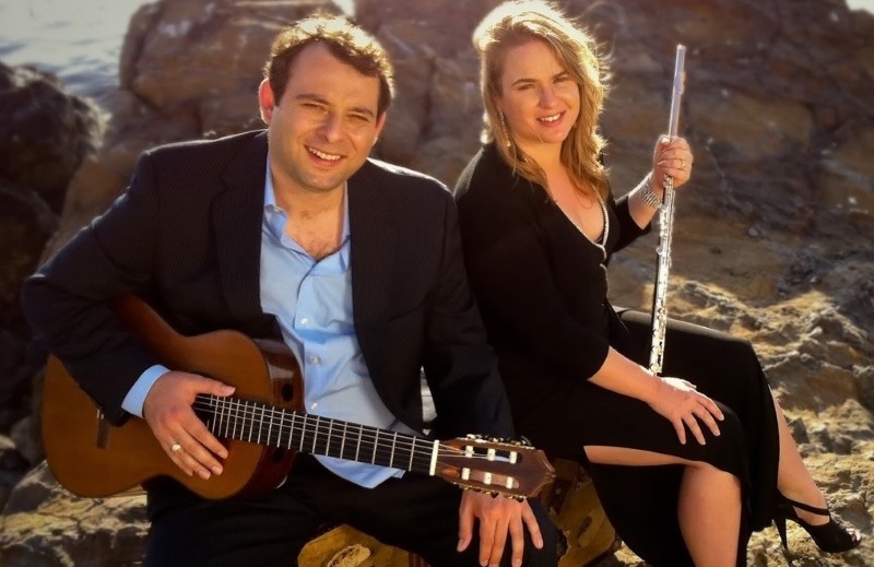 A man with a guitar and a woman with a flute
