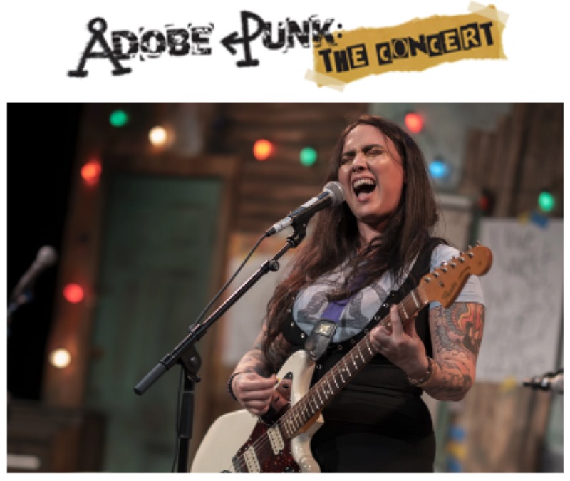 A woman singing while playing guitar