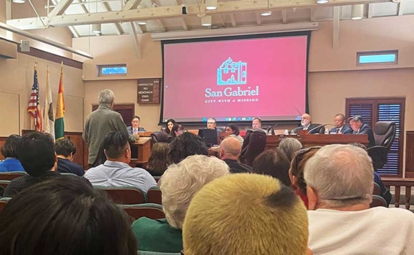A council meeting with a screen and audience attending