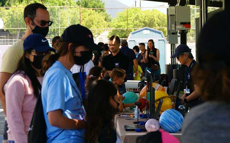 People looking at a model of the solar system