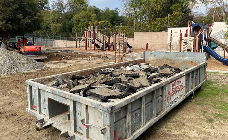 asphalt pieces in a dumpster