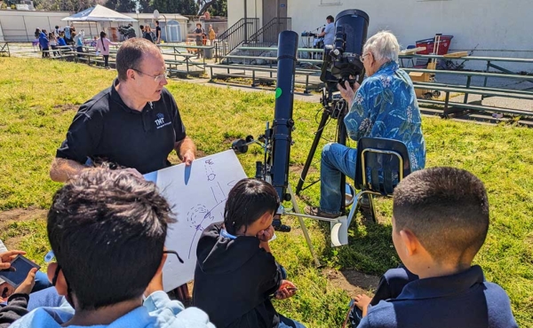 students around a telescope