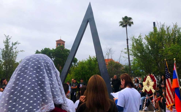 people stand around a monument