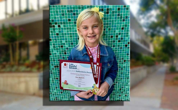 A student holding an award with her hand