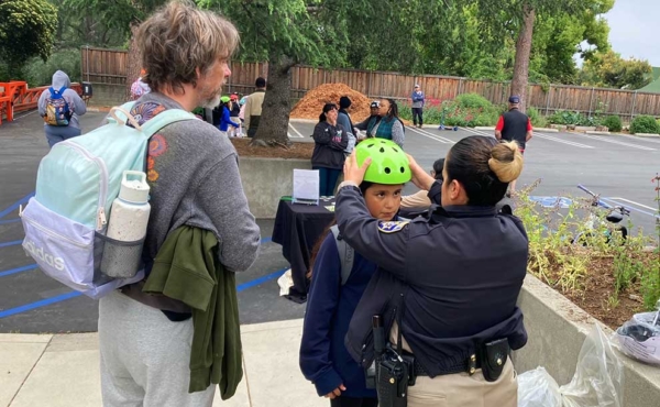 a person adjusting a helmet for a child on a bike