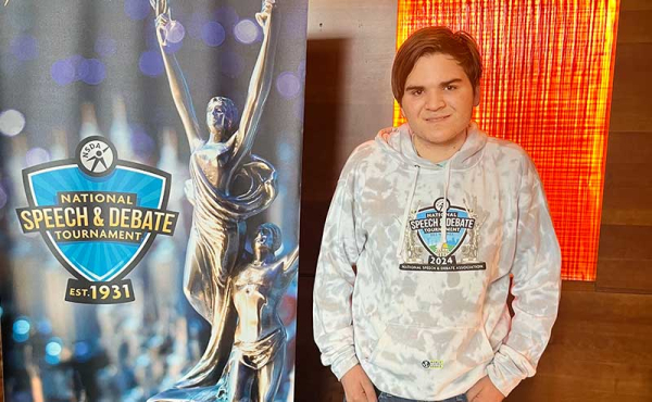 A kid standing next to a banner