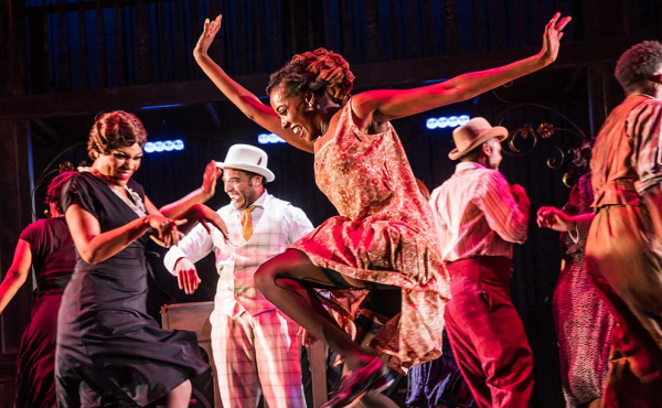 A woman and ensemble dancing