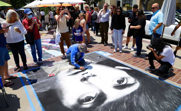 An artist draws a photo with chalk