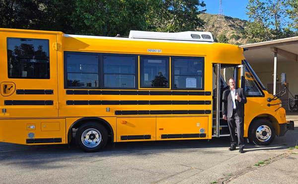 A man standing next to an electric bus