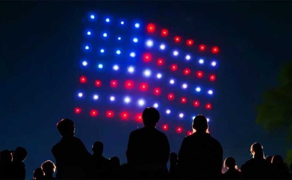 spectators watching a drone show of an American Flag