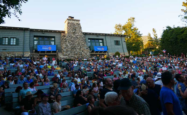 People sitting on benches attending a concert