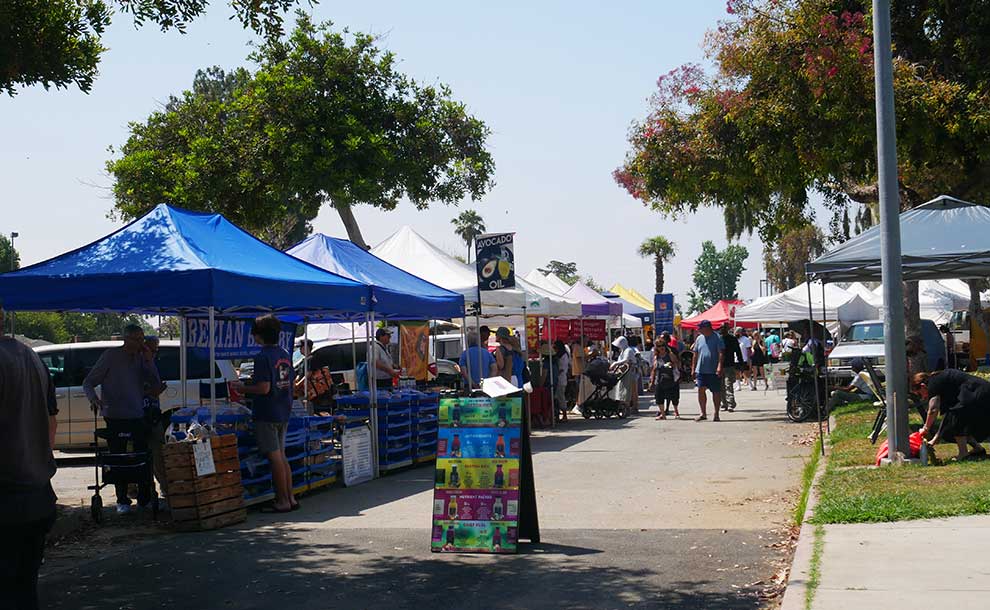 a sign and tents with produce