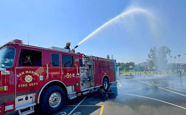 A fire engine spraying water onto a field