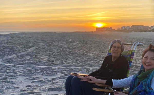 2 women holding hands at sunset