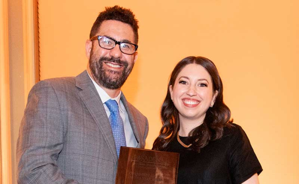 a man holding an award and a woman smiling