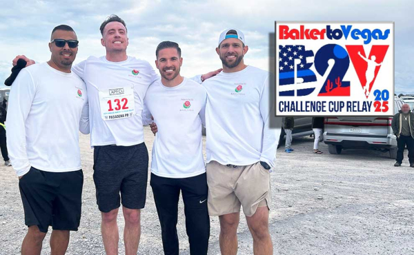 4 guys posing for a photo next to a design