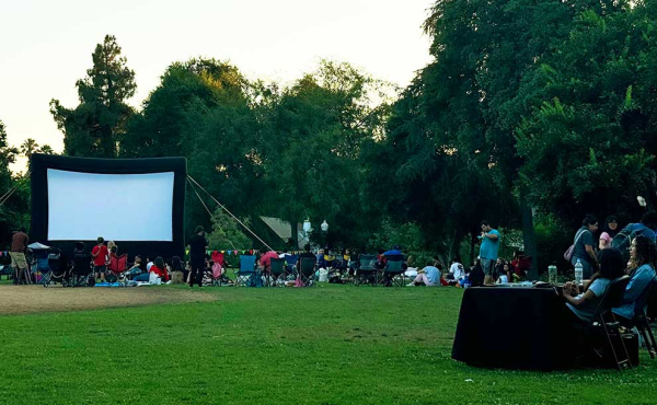 a giant screen and people having a picnic at park