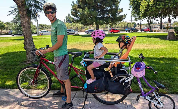 A man and two kids on a bike