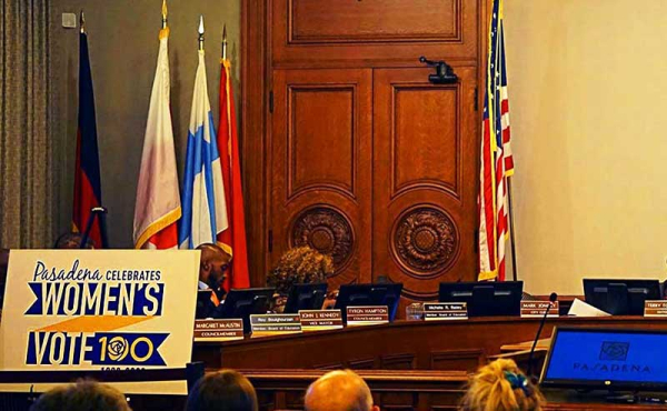 A sign commemorating Women Voting in a city council chamber