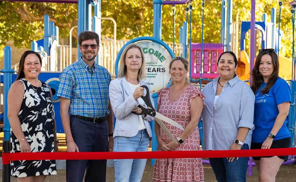 People standing in front of a red ribbon