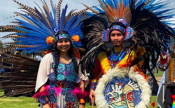 two dancers in traditional Aztec costumes