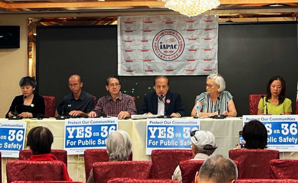 a group of people behind a table at a press conference