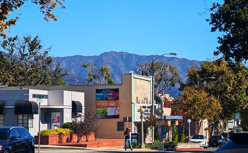a theatre building and mountains in the background