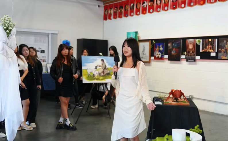 a student showcasing her art piece