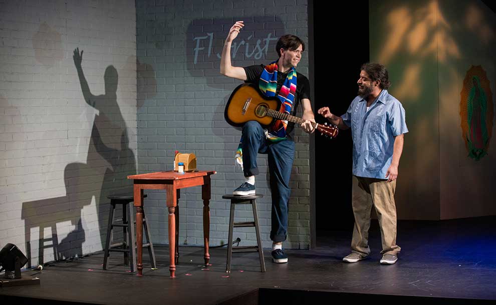a man playing the guitar and another listening